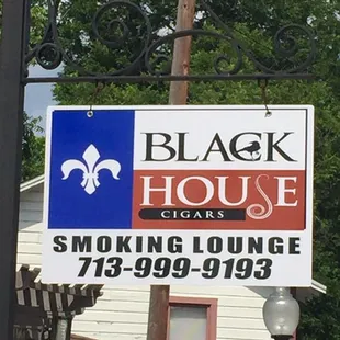 The sign in front of the smoking lounge and store