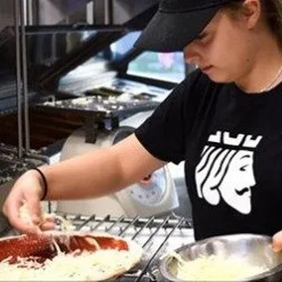 a woman making a pizza