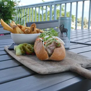 a wooden cutting board with a sandwich and french fries on it