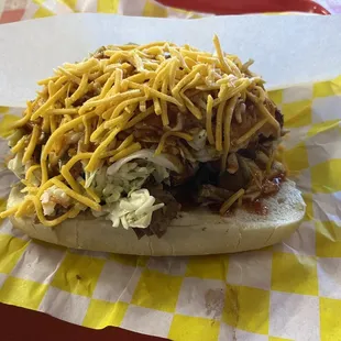 The Alpha Dog -- bacon-wrapped hotdog with brisket, onion rings, slaw, shredded cheddar and BBQ sauce.