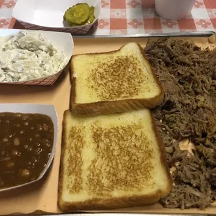 Pulled pork, baked beans, sour cream potato salad and Texas toast. Spicy pickles are good too!