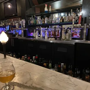 a glass of beer on a bar counter