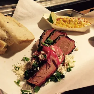 Our SATX. Smoked brisket with cotija cheese, pickled red onions, and cilantro and served with warm tortillas and corn in a cup.