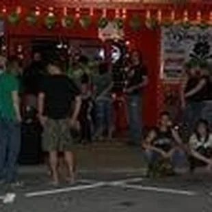 a group of people standing in front of a restaurant