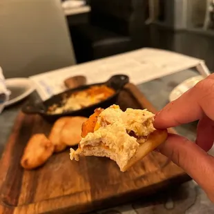 a hand holding a piece of bread