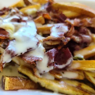a plate of french fries with bacon and cheese