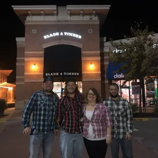 three people standing in front of the store