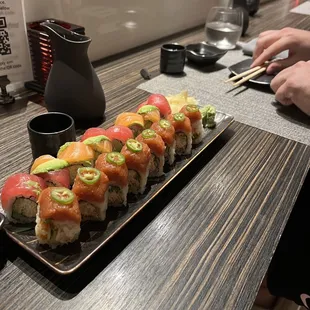 a plate of sushi and chopsticks on a table