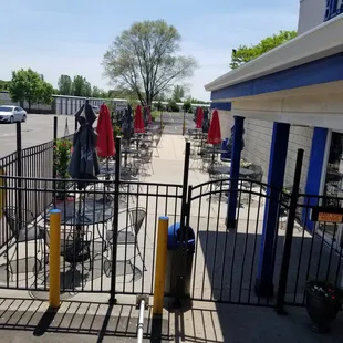 a parking lot with tables and umbrellas