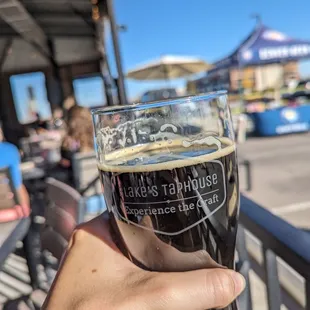 a hand holding a glass of beer