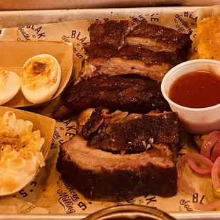 Delicious rib plate! With deviled eggs, and Mac &amp; cheese sides.  Jalapeño cornbread and homemade pickles as accompaniments.