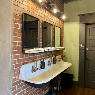 a bathroom with a brick wall