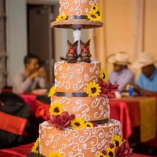 a three tiered cake decorated with sunflowers