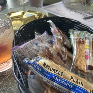 a glass of iced tea and a basket of snacks