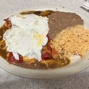 Cheese enchiladas plate with 2 over easy eggs on top