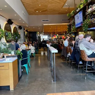 View of inside of restaurant from front looking back. Super cute, very clean, fun + happenin&apos; place with big bar area up front.