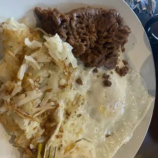 Huevo Ranchero plate with hash browns. Refried beans dry, over medium eggs over cooked!