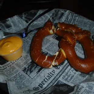A warm giant pretzel with cheese sauce.