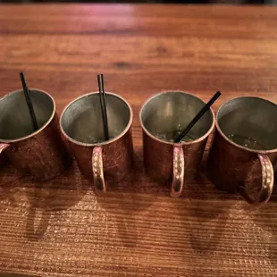 a row of copper mugs