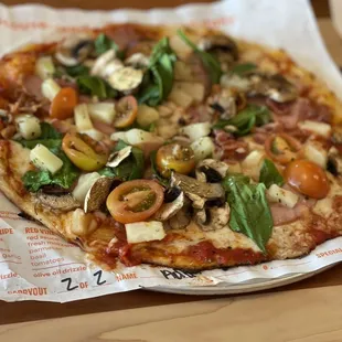 a whole pizza on a paper plate