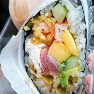 a hand holding a sushi wrap