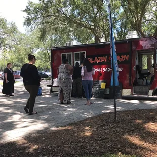a group of people standing in front of a food truck