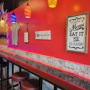 a bar with stools and neon lights