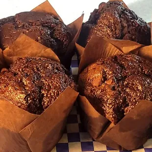 several muffins in brown paper bags