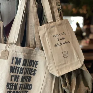 two tote bags hanging on a rack