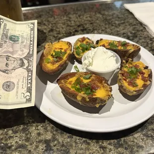 a plate of baked potatoes with cheese and green onions