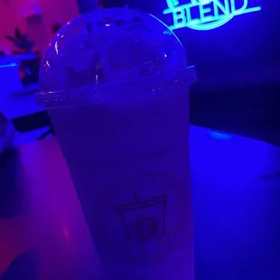 a cold drink in a plastic cup on a table