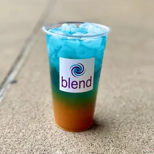 a blue and orange drink with ice