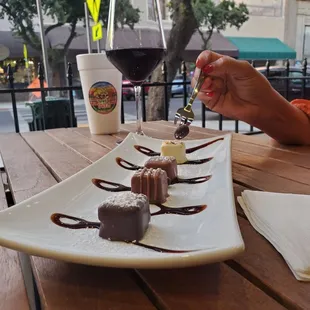 a plate of desserts and a glass of wine
