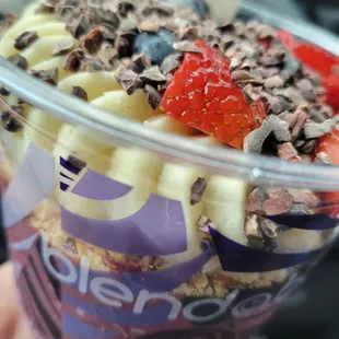 a hand holding a cup of yogurt