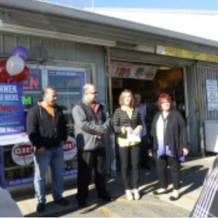 a group of people standing outside of a store
