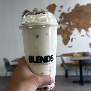 a hand holding a cup of ice cream