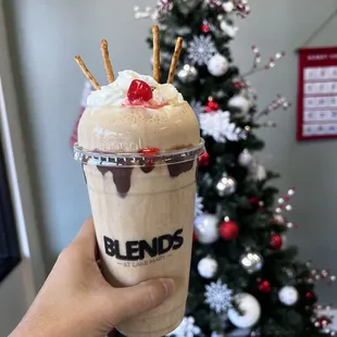 a hand holding a cup of ice cream