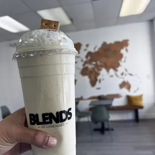 a hand holding a cup of iced coffee