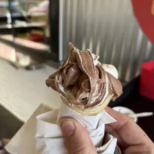 a hand holding an ice cream cone