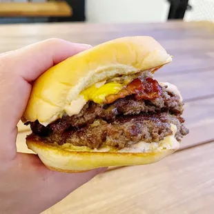 a hand holding a hamburger