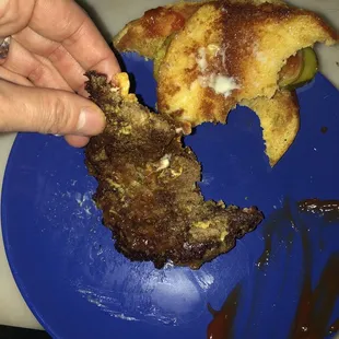 a blue plate with a half eaten burger
