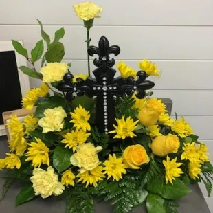 Yellow Roses, yellow carnations,  yellow daisy's with a beautiful Cross placed in the center.