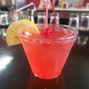a red drink with a cherry garnish