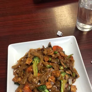Wide rice noodles with tofu in front, pad Thai with beef in back