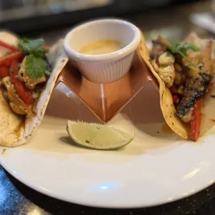 a plate of tacos and a bowl of sauce