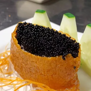 Inari (tofu skin) stuffed with sushi rice and black caviar.⁣