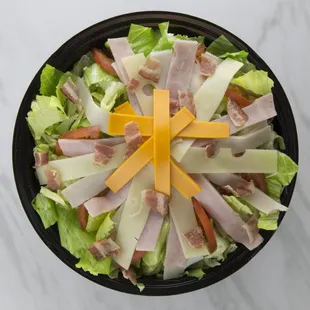 a salad with ham, cheese, and lettuce