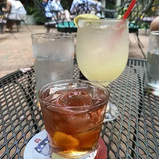 a glass of lemonade and a drink on a table