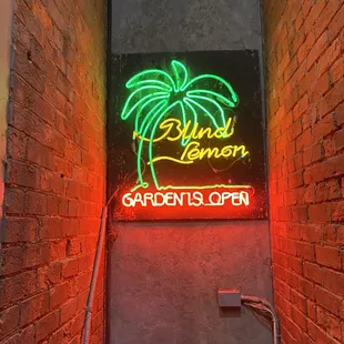 a neon sign on a brick wall