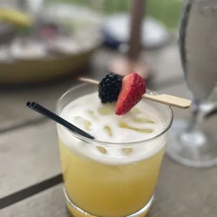 a glass of lemonade with strawberries on a stick